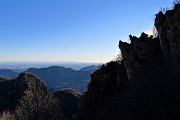 85 Roccioni cima Corna Camoscera in controluce con vista verso la pianura